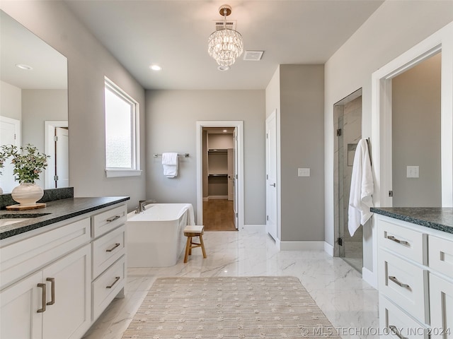 bathroom featuring a chandelier, tile flooring, vanity, and a washtub