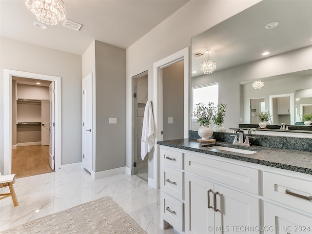 bathroom with oversized vanity, a chandelier, and tile floors