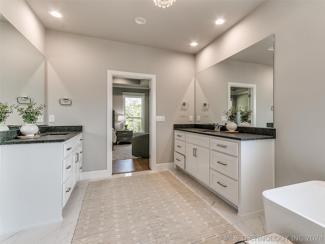 bathroom featuring a bath to relax in, tile floors, and dual bowl vanity