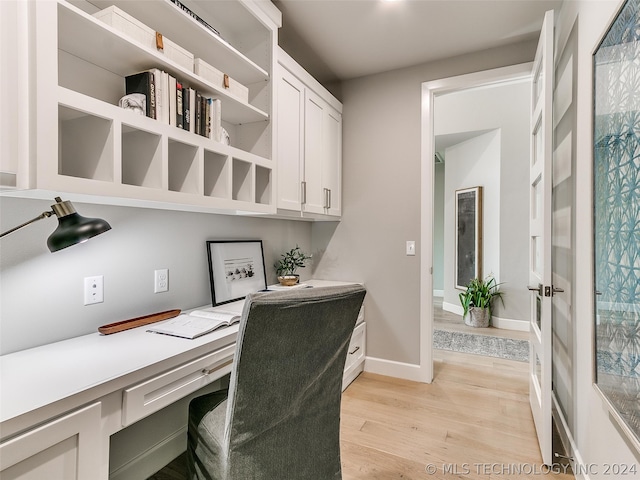 home office featuring built in desk and light hardwood / wood-style flooring