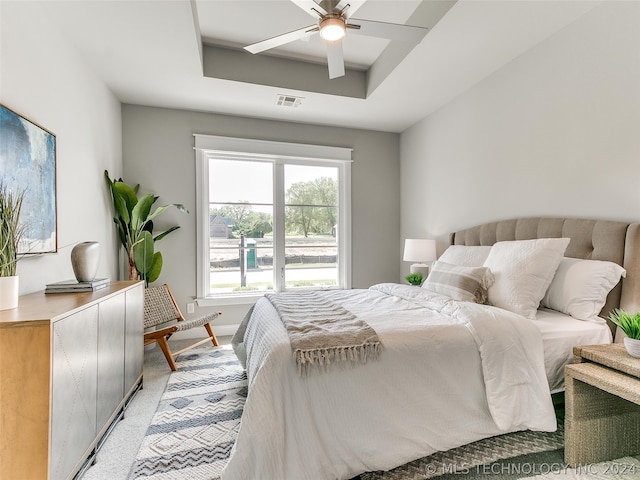 bedroom featuring carpet, ceiling fan, and a tray ceiling