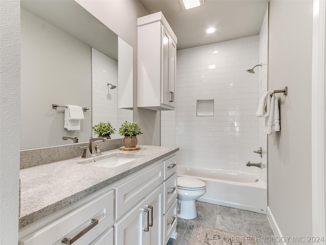 full bathroom featuring tile flooring, tiled shower / bath, large vanity, and toilet