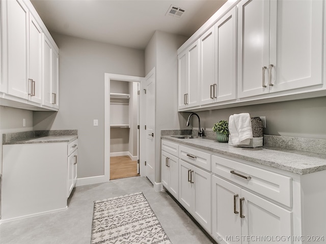 laundry room with sink and light tile floors