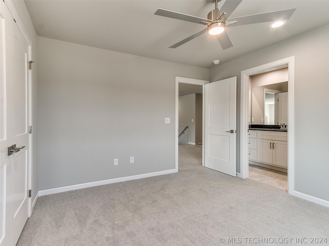 unfurnished bedroom with light carpet, connected bathroom, and ceiling fan