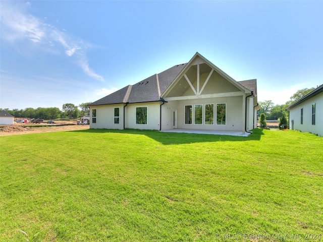 rear view of house with a lawn and a patio