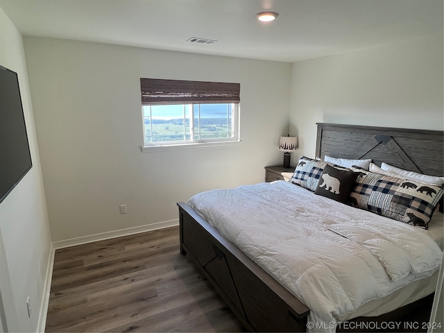 bedroom with dark hardwood / wood-style flooring