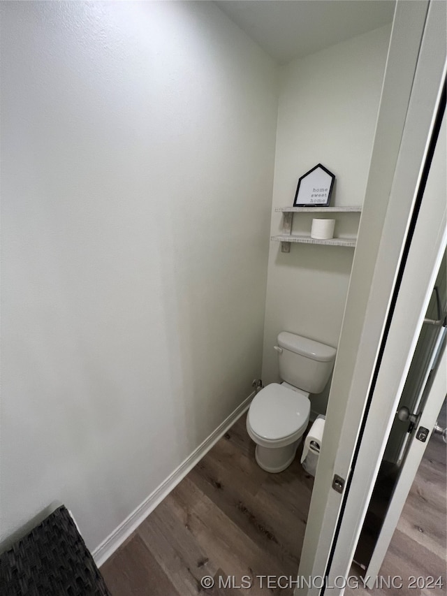 bathroom featuring toilet and wood-type flooring