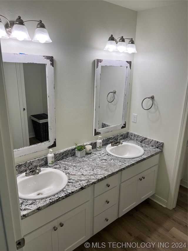 bathroom with dual vanity and wood-type flooring