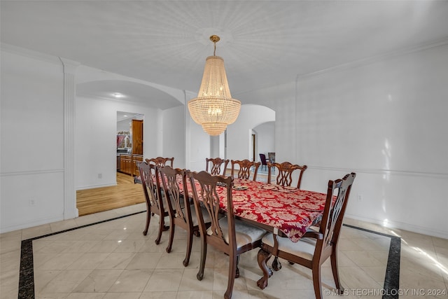 tiled dining space with a notable chandelier and ornamental molding