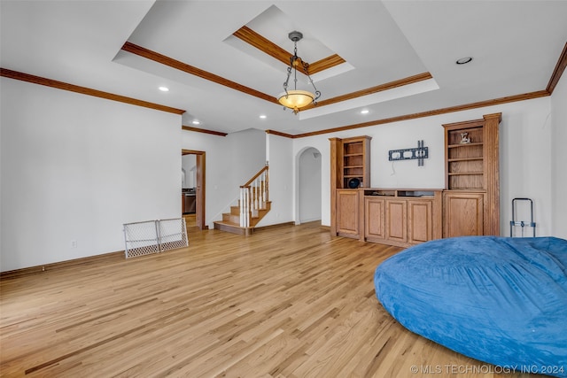 living room featuring light hardwood / wood-style flooring, ornamental molding, and a tray ceiling