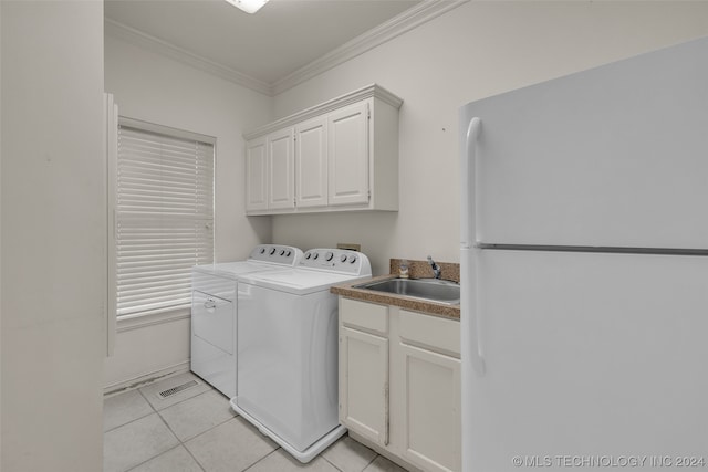 washroom with ornamental molding, independent washer and dryer, light tile floors, and sink