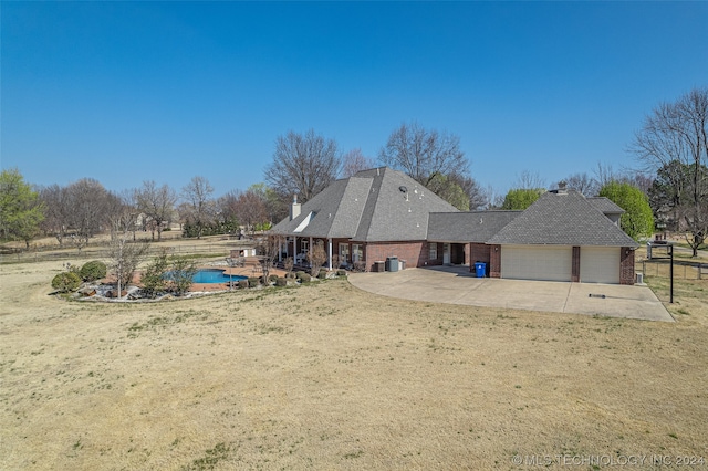 back of house featuring a lawn and a garage