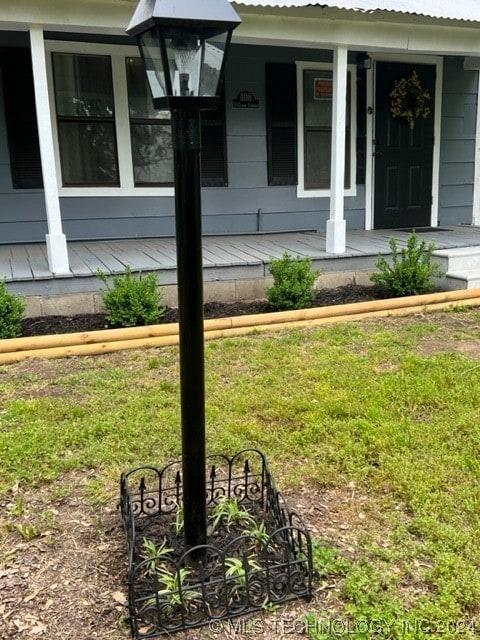 view of exterior entry with a lawn and covered porch