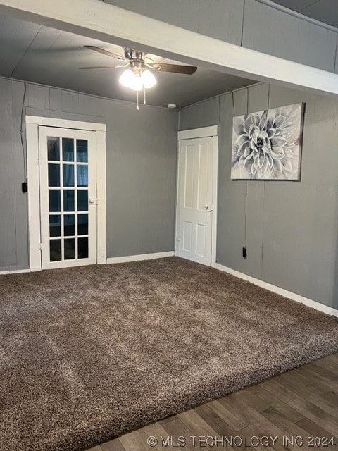 carpeted spare room featuring beamed ceiling and ceiling fan