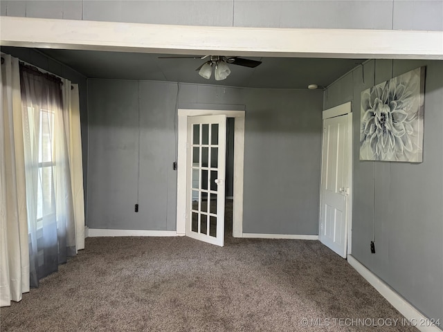 carpeted empty room featuring ceiling fan, beamed ceiling, and a healthy amount of sunlight