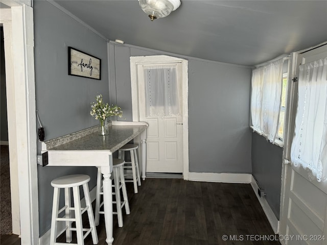 kitchen with a breakfast bar, dark hardwood / wood-style floors, and lofted ceiling