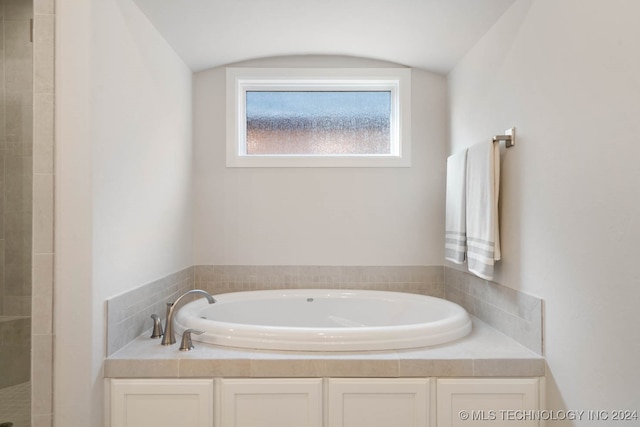 bathroom with lofted ceiling and plus walk in shower