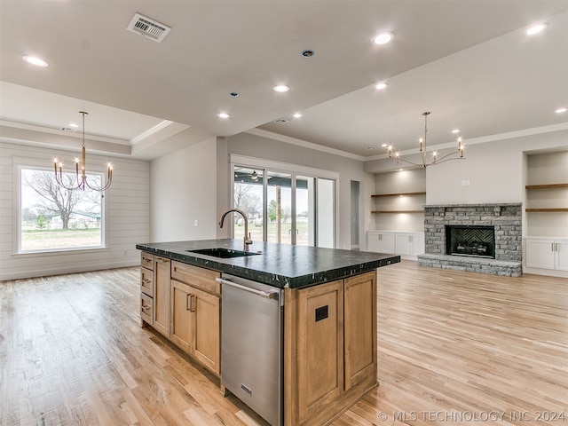 kitchen featuring sink, a center island with sink, light hardwood / wood-style floors, and an inviting chandelier