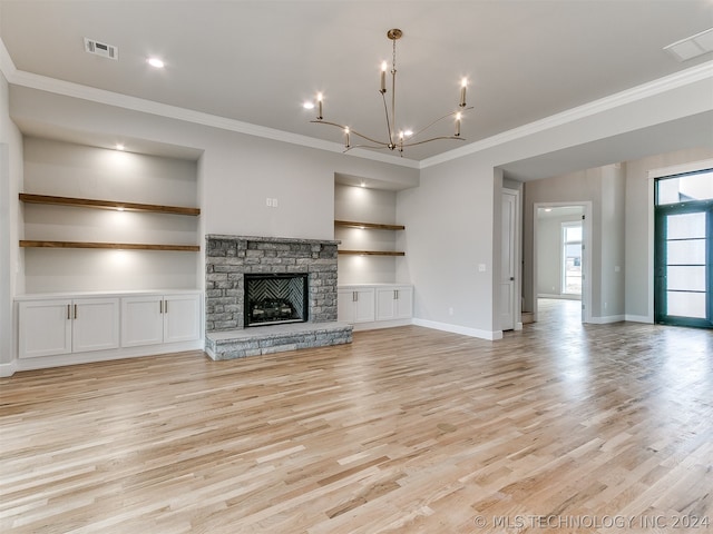 unfurnished living room featuring ornamental molding, light hardwood / wood-style floors, a chandelier, and a fireplace