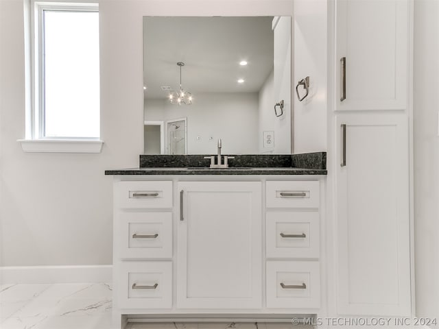 bathroom featuring tile flooring, vanity, and a notable chandelier