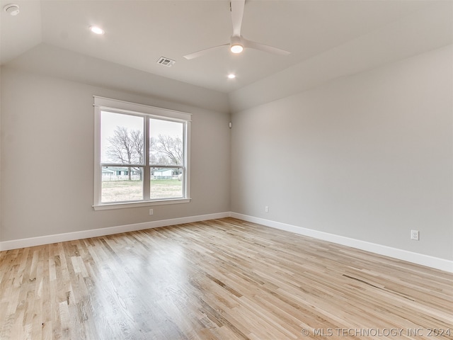 spare room featuring lofted ceiling, ceiling fan, and light wood-type flooring