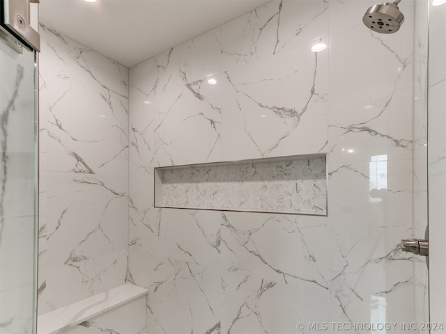 interior details with a tile shower