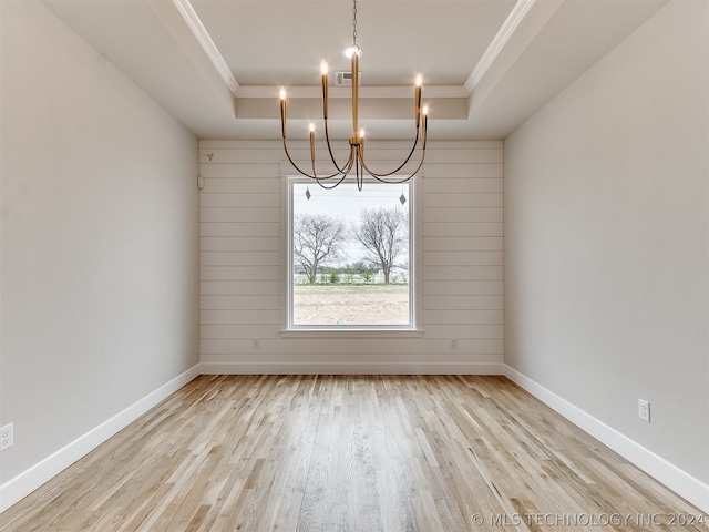 unfurnished room featuring light hardwood / wood-style flooring, a chandelier, and a tray ceiling