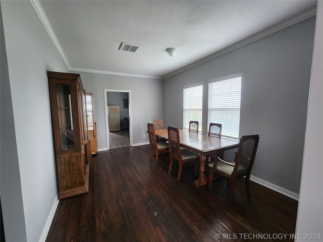 dining space featuring crown molding, dark wood-type flooring, and a textured ceiling