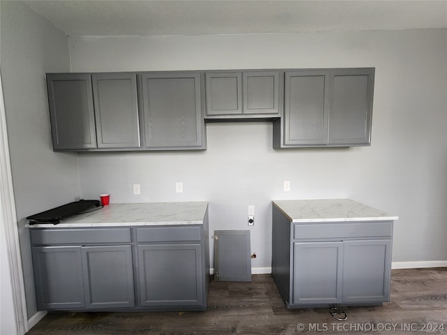 kitchen with dark wood-type flooring and gray cabinetry