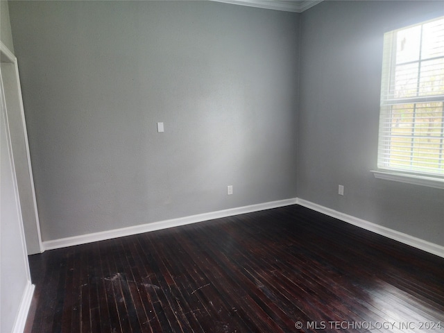 spare room with ornamental molding and dark hardwood / wood-style flooring