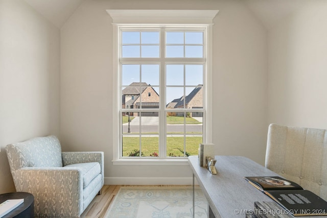 home office featuring lofted ceiling and light hardwood / wood-style floors