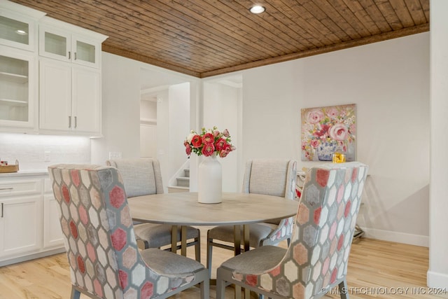 dining space with wood ceiling, light hardwood / wood-style floors, and ornamental molding