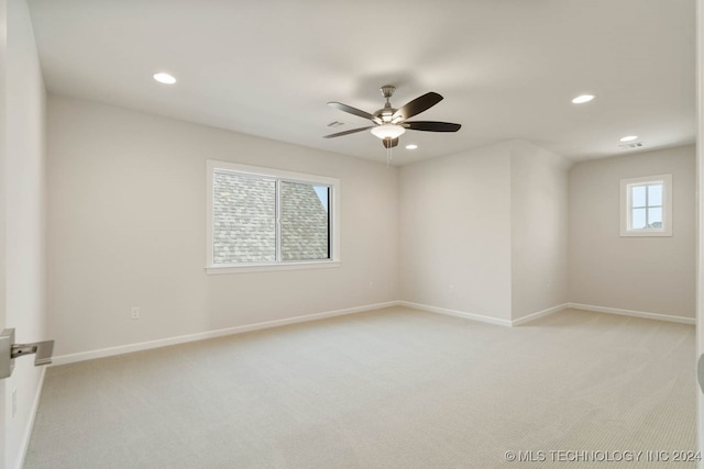 empty room with ceiling fan and light carpet