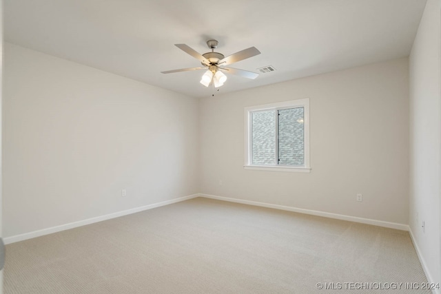 carpeted spare room with ceiling fan