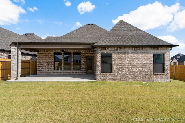 rear view of house with a patio area, a yard, and ceiling fan