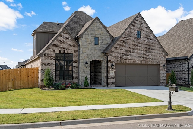 view of front of property featuring a garage and a front lawn