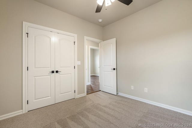 unfurnished bedroom featuring ceiling fan, light carpet, and a closet