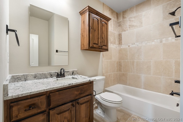 full bathroom featuring toilet, vanity with extensive cabinet space, tile floors, and tiled shower / bath combo