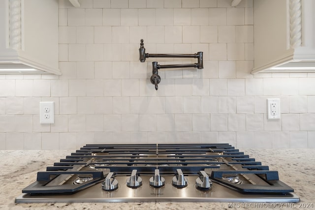 room details with backsplash and stainless steel gas stovetop