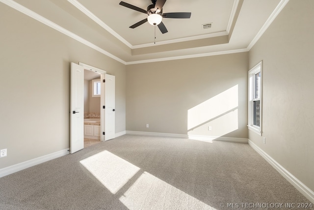 empty room with crown molding, light colored carpet, ceiling fan, and a tray ceiling