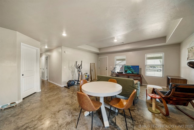 dining area featuring recessed lighting, a raised ceiling, finished concrete flooring, and baseboards