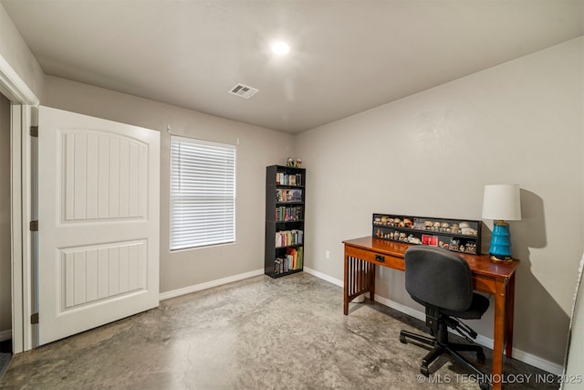 office space with visible vents, concrete floors, and baseboards