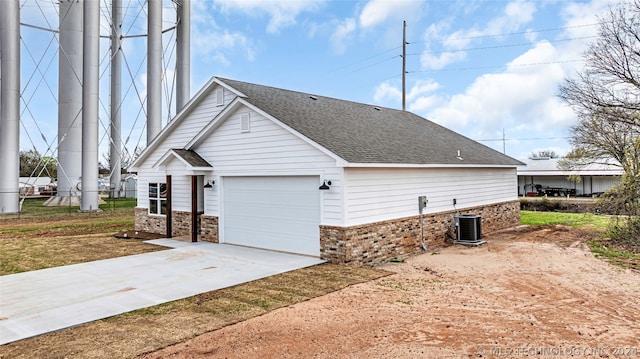 view of side of property with central AC unit and a garage