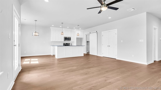 unfurnished living room with light hardwood / wood-style floors and ceiling fan