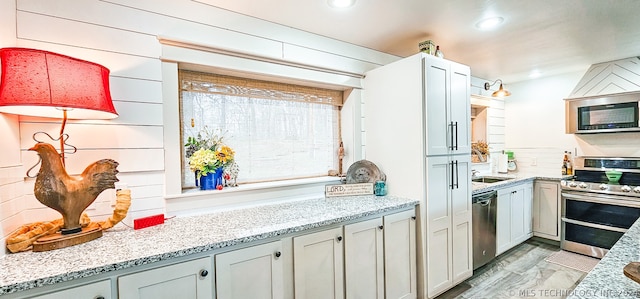 kitchen featuring stainless steel appliances and light stone countertops