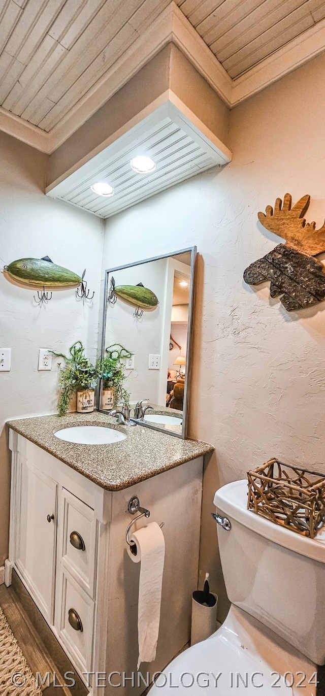 bathroom featuring hardwood / wood-style flooring, wooden ceiling, toilet, ornamental molding, and vanity