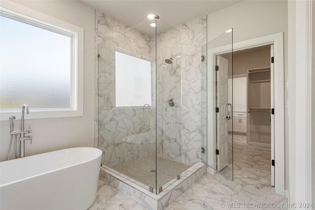 bathroom featuring plenty of natural light and independent shower and bath