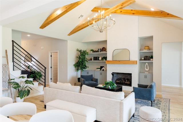 living room featuring built in shelves, a fireplace, lofted ceiling with beams, and light wood-type flooring