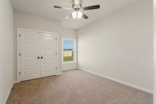 unfurnished bedroom featuring carpet, ceiling fan, and a closet