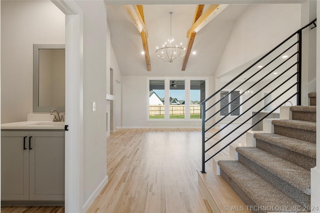 entryway featuring high vaulted ceiling, sink, beamed ceiling, a notable chandelier, and light hardwood / wood-style floors